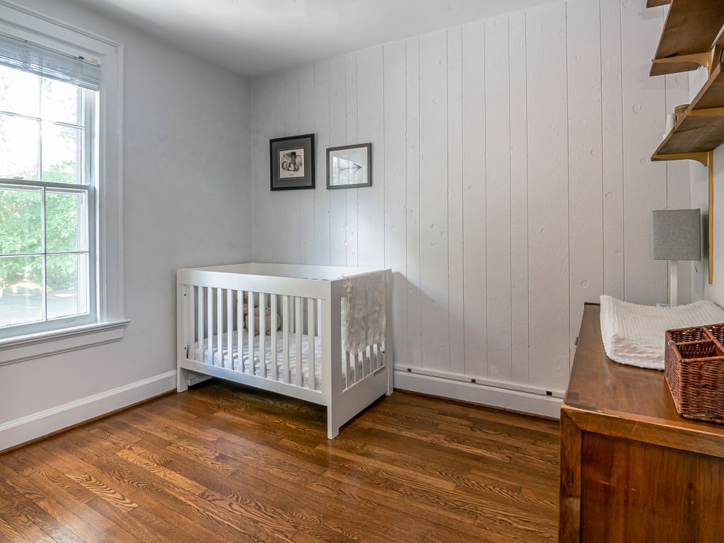 Chambre de bébé lumineuse avec un lit et une commode aux normes de sécurité