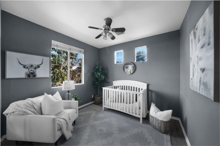 Chambre de bébé moderne aux tons gris avec lit à barreaux conforme aux normes