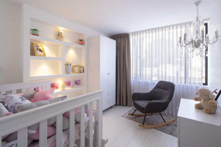 Chambre de bébé moderne et lumineuse avec commode blanche et fauteuil d'allaitement