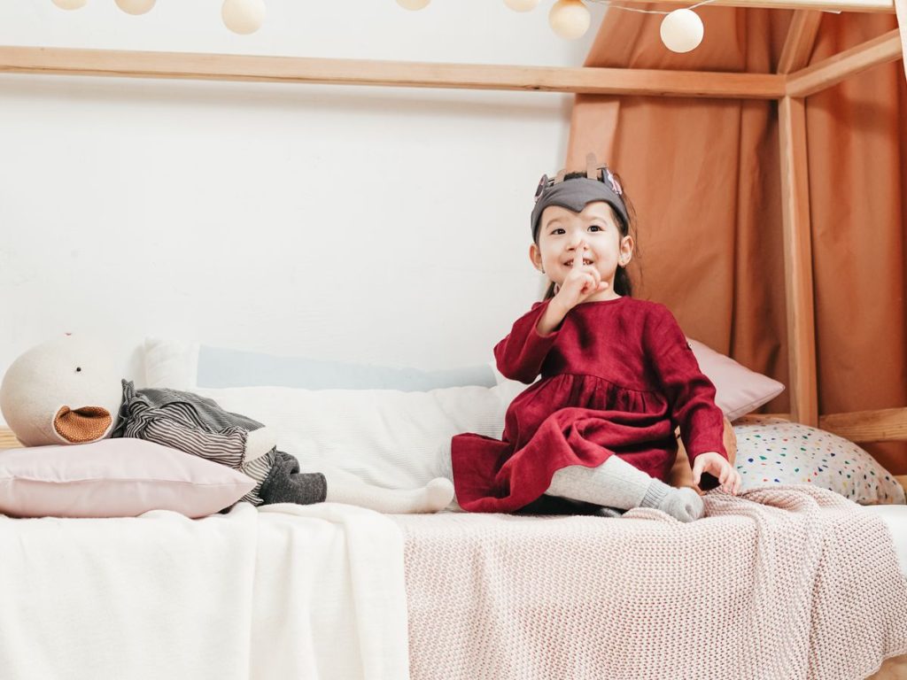 Jeune enfant assis dans son lit cabane au ras du sol