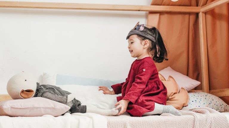 Lit cabane en bois clair dans une chambre d'enfant moderne