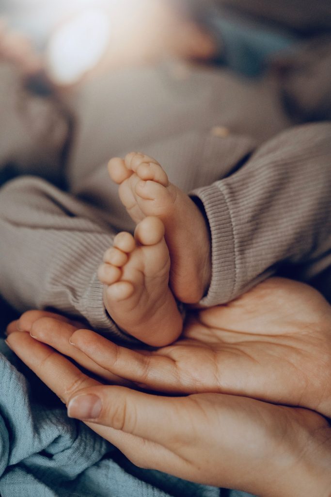 Les petits pieds d’un nouveau-né posés dans la main d’un parent