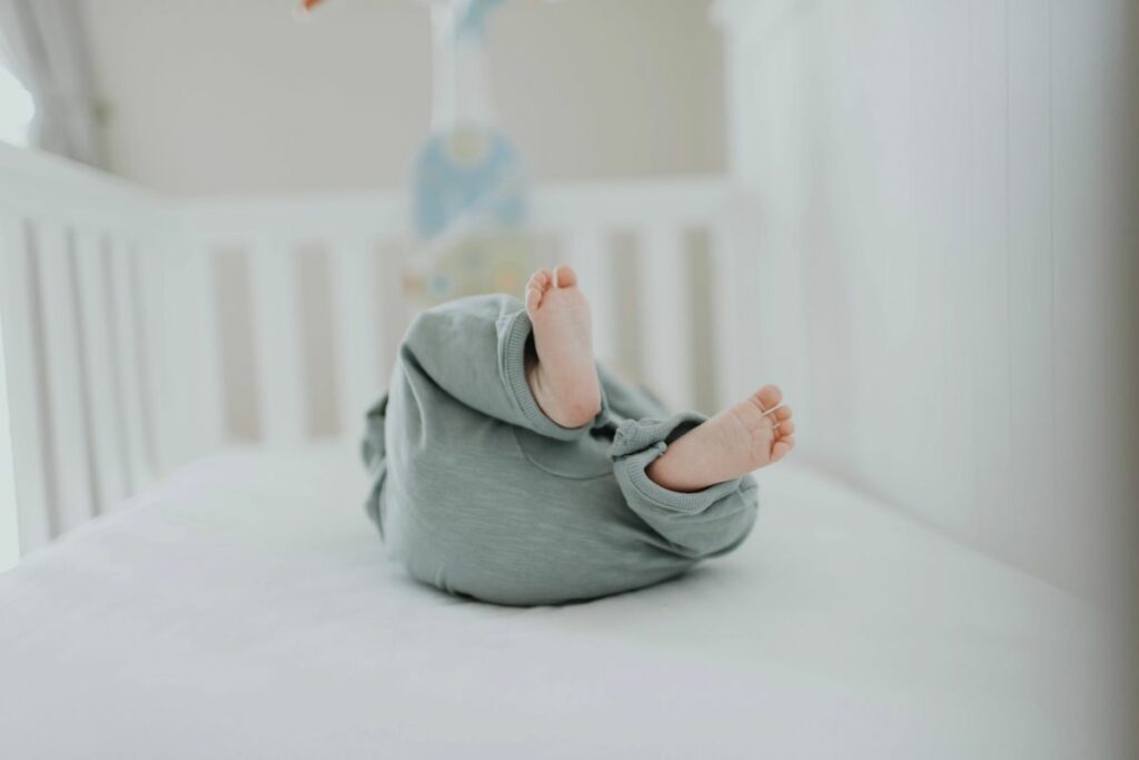 Bébé en gigoteuse dans un lit dégagé, sans couverture