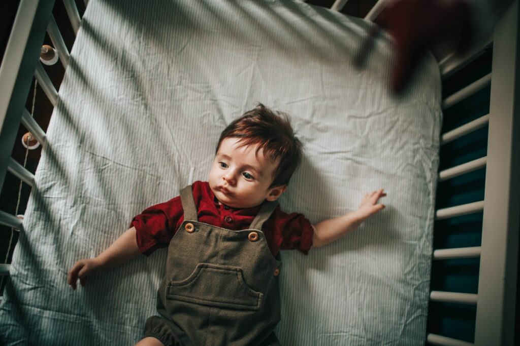 Bébé allongé sur un matelas ferme et plat, dans un lit dégagé