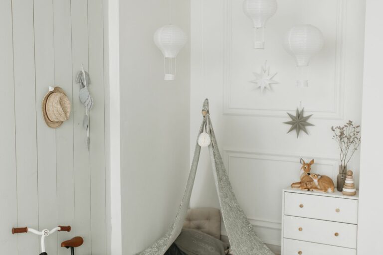 Coin chambre de bébé complet : commode blanche, tente, draisienne et décor ballons, tons neutres