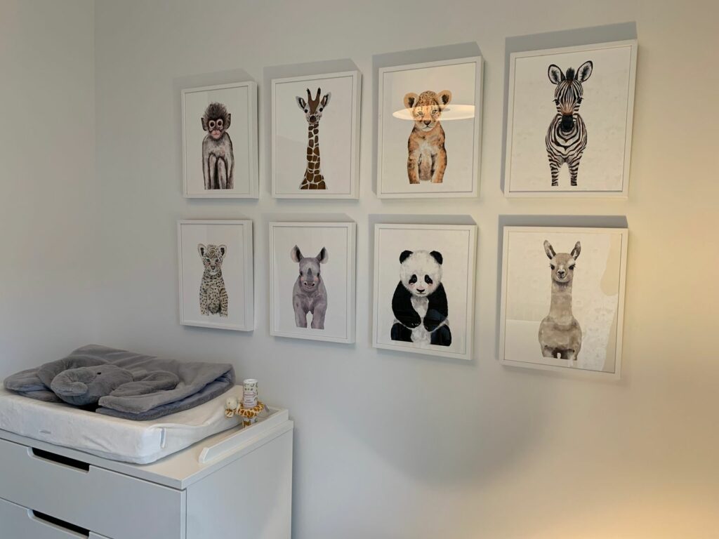Cadres d'illustrations d'animaux au-dessus d'un coin change dans une chambre de bebe