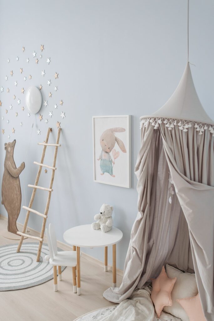 Chambre de bébé garçon en bleu grisé avec étoiles et décor forêt