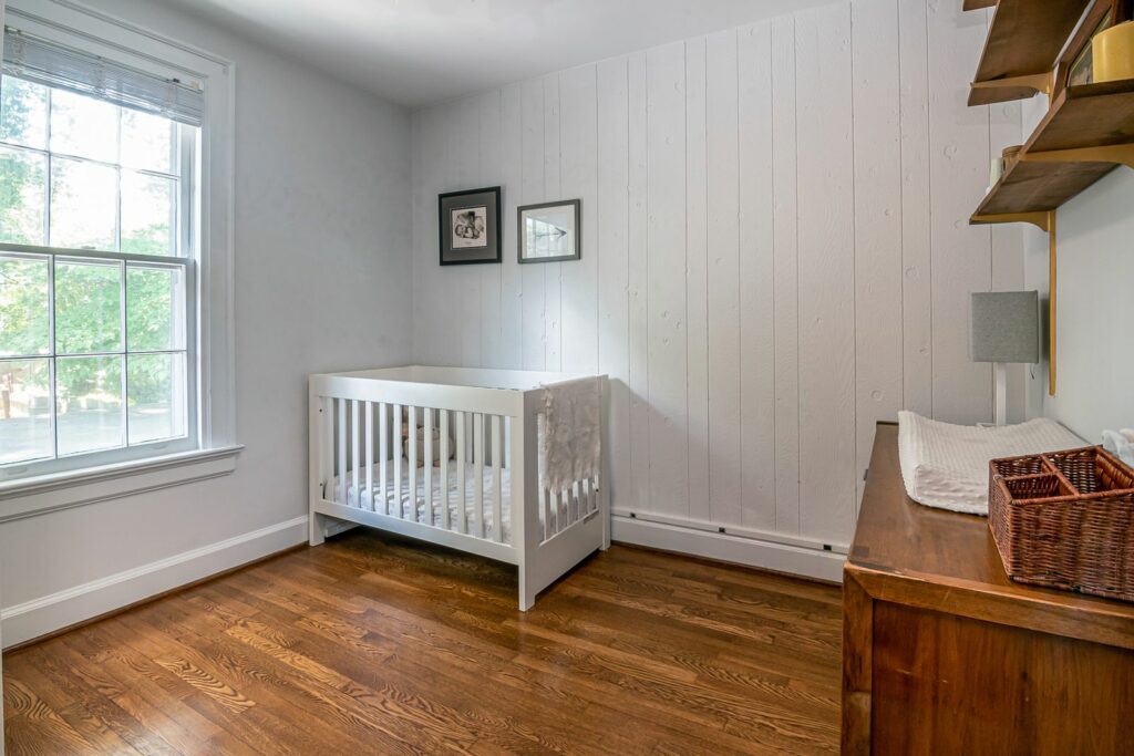 Chambre de bébé mixte en blanc et bois clair, base lumineuse
