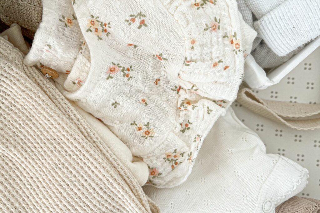Vêtements de bébé aux tons neutres préparés et pliés, prêts à être listés