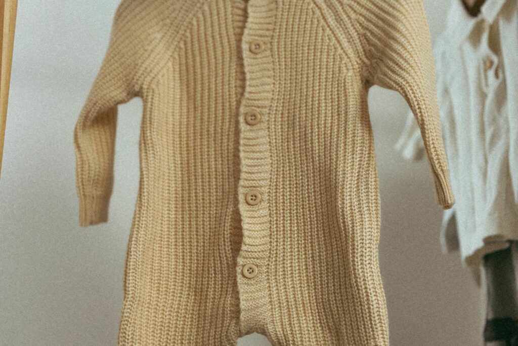 Quelques pièces de layette bien choisies suspendues sur un portant en bois