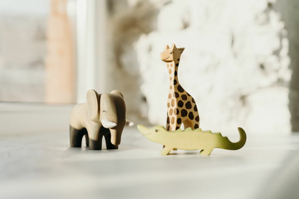 Figurines d'animaux en bois (éléphant, girafe, crocodile) sur un rebord de fenêtre