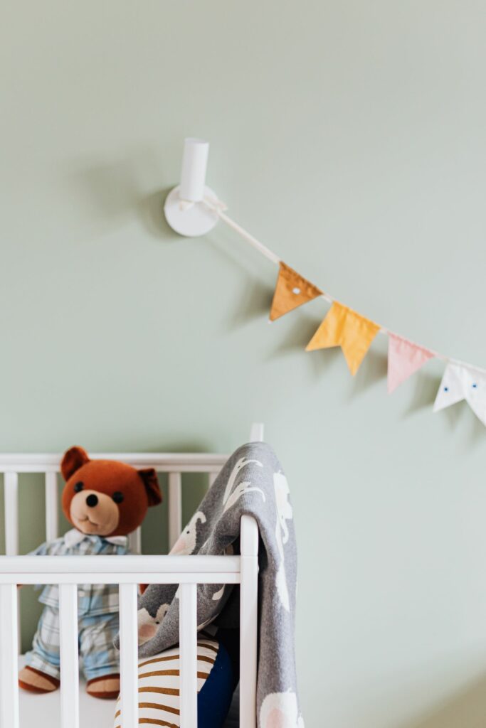 Guirlande de fanions dans une chambre de bébé aux tons sauge