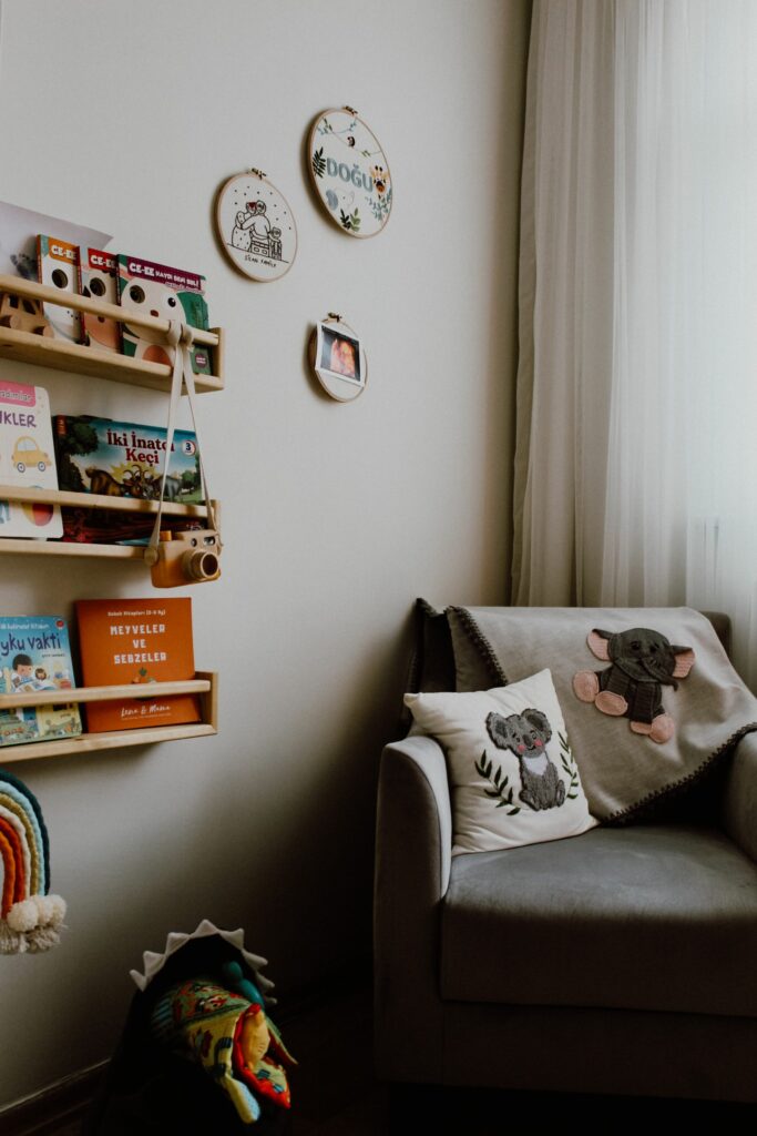 Coin lecture d'une chambre de bébé avec étagères à livres et fauteuil