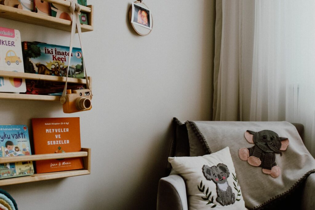 Étagères à livres murales dans une chambre de bébé, à côté d'un fauteuil et d'un coin lecture