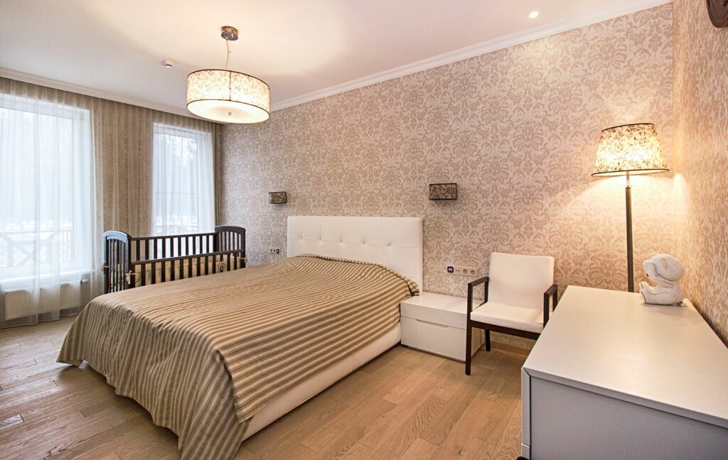 Chambre des parents avec un lit double et un lit à barreaux de bébé accolé