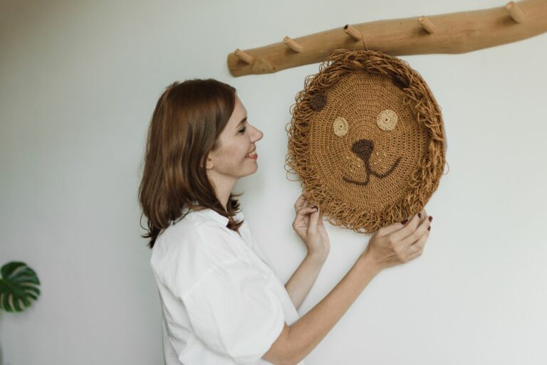 Femme accrochant une décoration murale lion en crochet dans une chambre claire