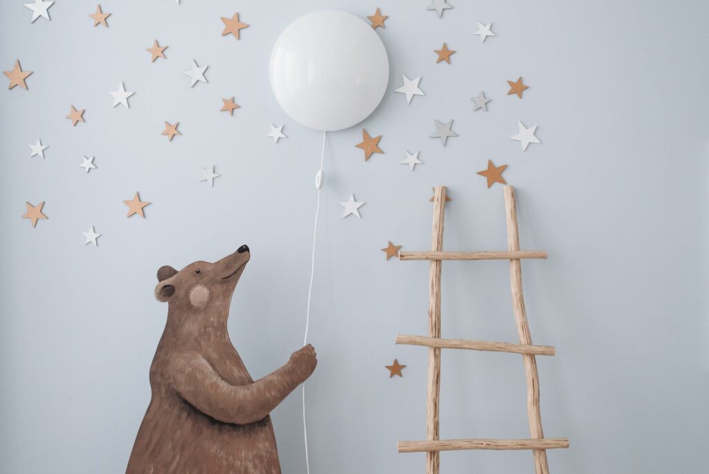 Veilleuse douce et decor mural etoile dans une chambre de bebe sur le theme des animaux